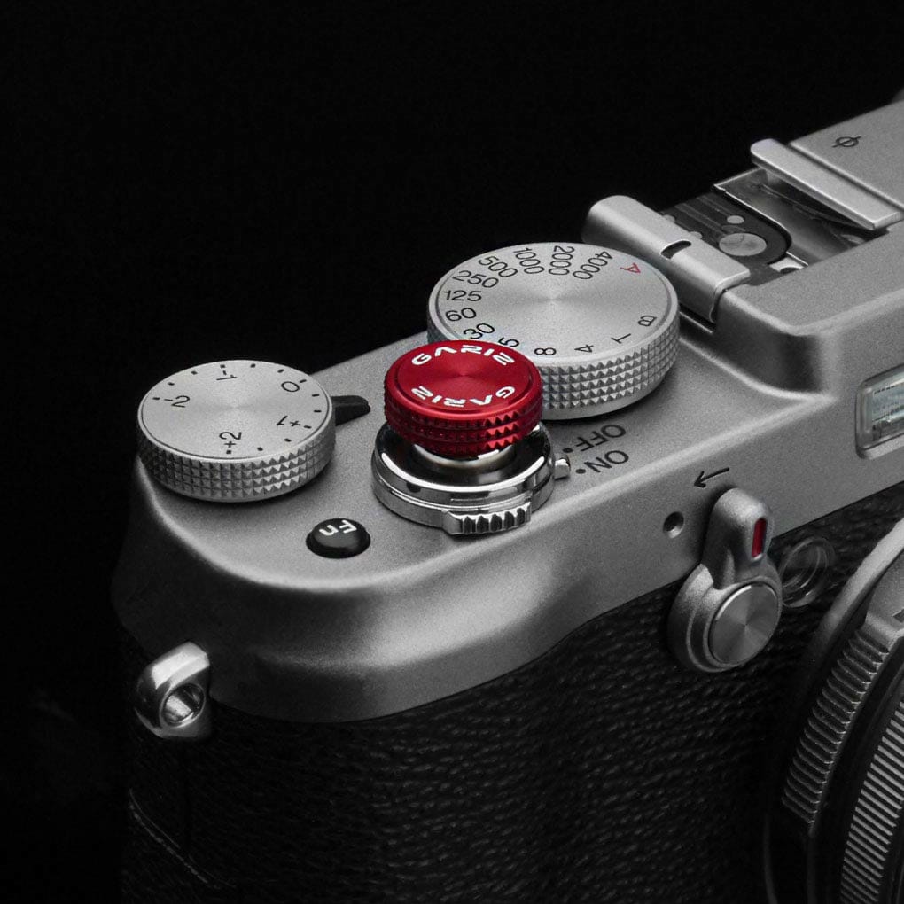 Auslöseknopf in Rot von GARIZ Design an silber schwarzer Kamera